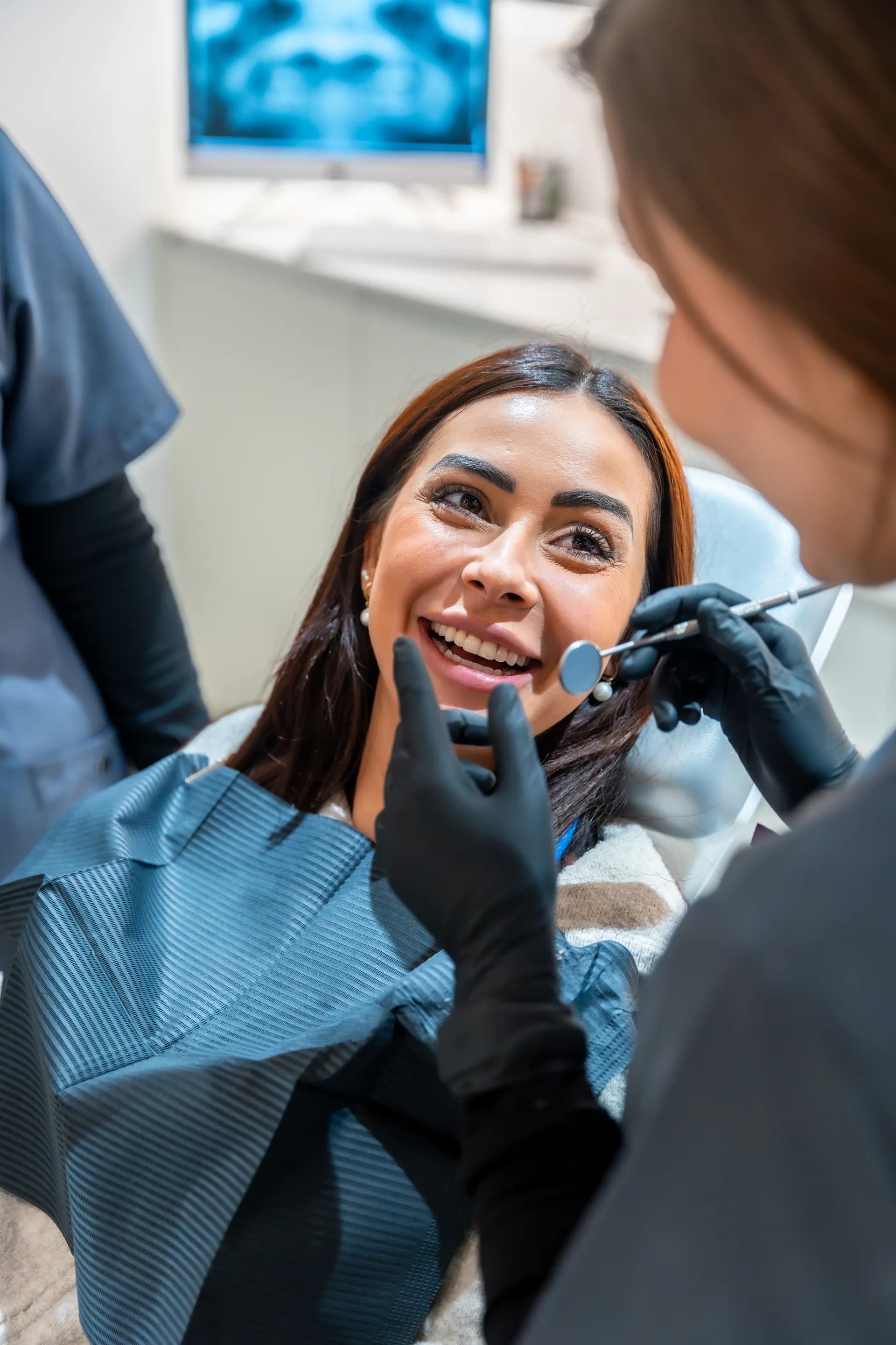 Smiling patient during a dental checkup in a modern, friendly dental clinic