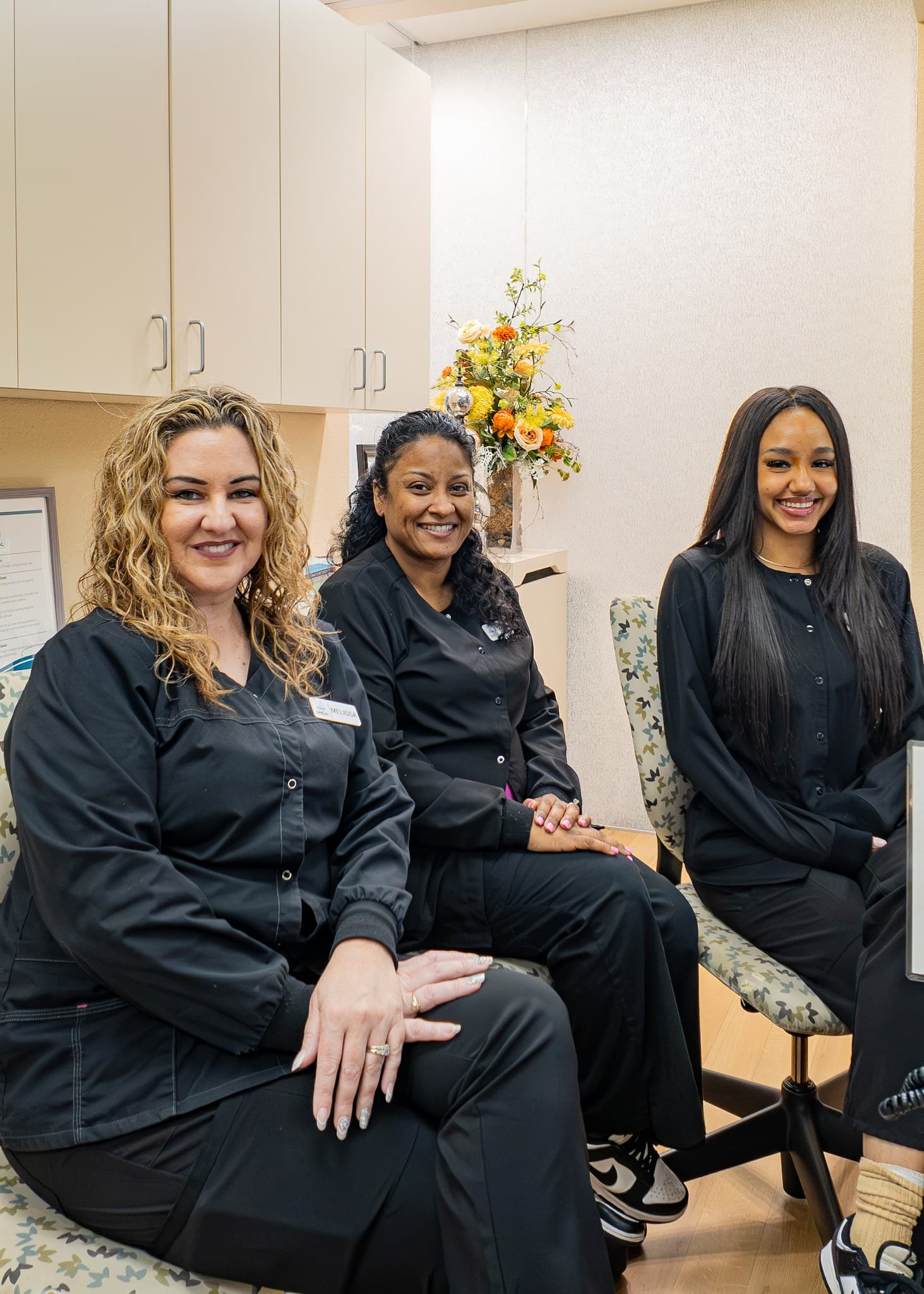 Three smiling J Street Dental Group team members at reception, where we check PPO insurance benefits for patients of our Sacramento dental office