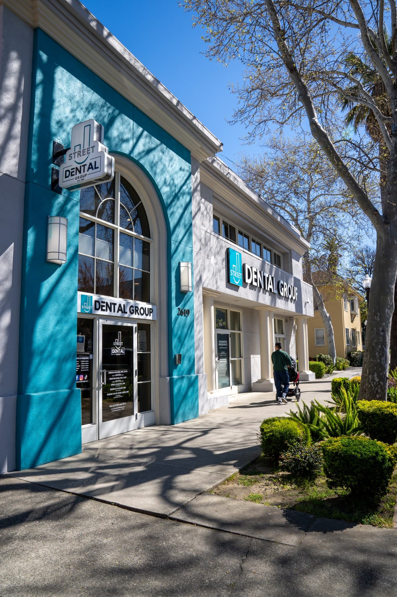The teal-and-white J Street Dental Group building at 2619 J Street, with its signs and glass entrance door, home of our emergency dentist in Sacramento